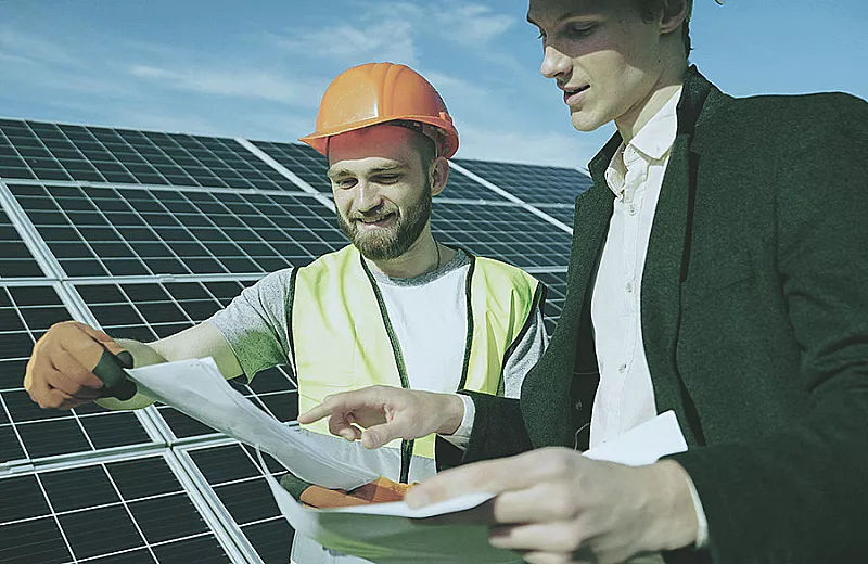 engineer and staff working on a solar panel