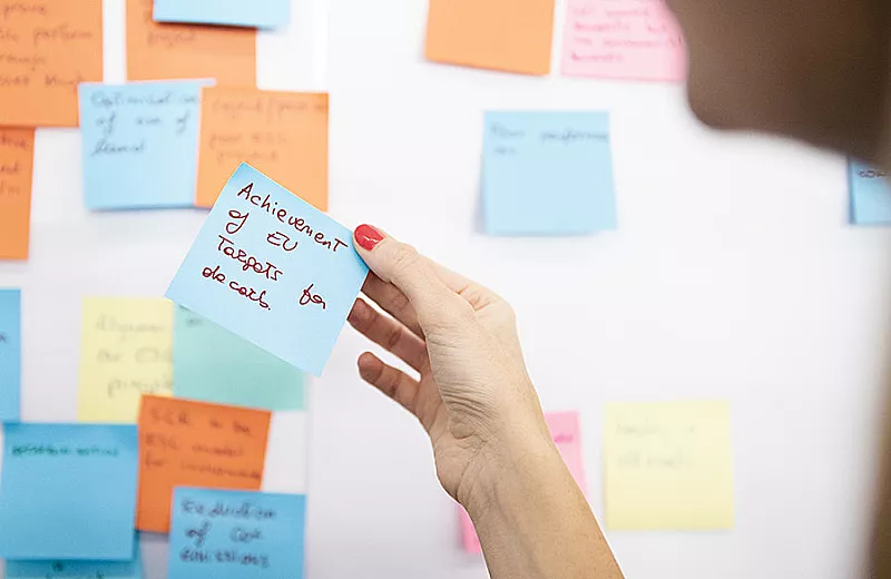 a hand holding a post-it note